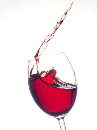 Splashing glass of red wine on a bright background