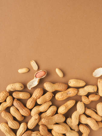 Organic peanuts on a brown studio background with space for text, view from above, healthy food...