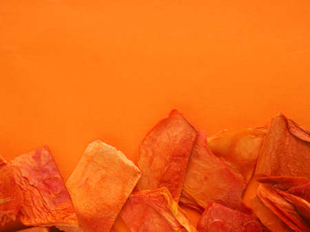 Dried organic papaya slices on an orange studio background, healthy food concept, view from above,...