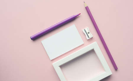 Mock up background with business cards and pencils on a pink paper backdrop
