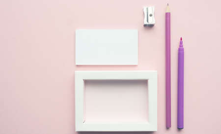 Mock up background with business cards and pencils on a pink paper backdropの写真素材