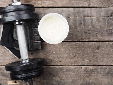 Dumbbell with protein shake on a rustic wooden floor, view from aboveの写真素材
