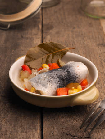 Delicious rollmops in a ceramic bowl on a wooden kitchen tableの写真素材