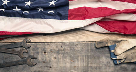 Labor Day concept, Flag of the United States with tools on a wooden workbench
