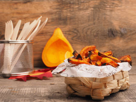 Tasty organic pumpkin fries in a small basket, seasonal or vegetarian food conceptの写真素材