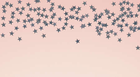Silver plastic stars on a bright pink paper background with space for textの写真素材