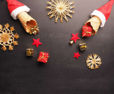 Christmas gifts fall out of an ice cream cone decorated with the Santa Claus hat