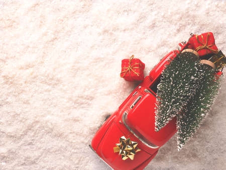 Red Christmas truck with Christmas trees and gift boxes in the snow, view from above, space for your text on the left sideの写真素材
