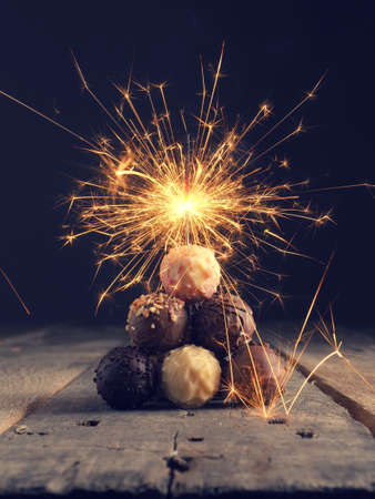 Stacked chocolated balls on a rustic table with a sparklerの写真素材