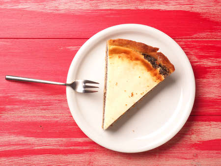 Piece of tasty organic cheese cake with poppyseed on a white plate