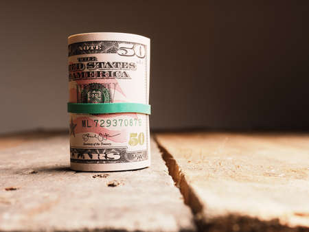 Different Dollar banknotes on a rustic wooden table, Income or savings amount concept