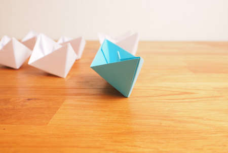 Teamwork business concept with paper boat on a wooden office table with space for textの写真素材