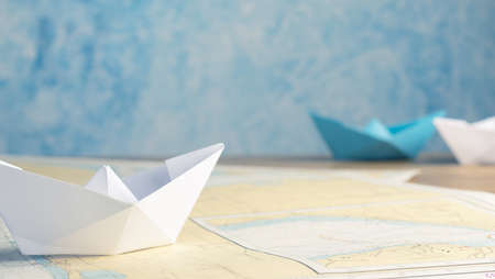 Teamwork business concept with paper boat on a wooden office table with space for textの写真素材
