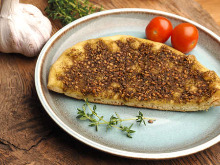 Tasty manaqish with thyme and sesame on a rustic blue ceramic plateの写真素材