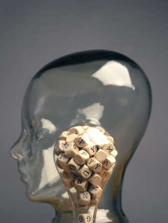 A lot of alphabetically labeled wooden cubes in a light bulb, creativity or educational conceptの写真素材