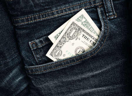 One dollar banknote in a jeans pocket, close up shot, last dollar, financial conceptの写真素材