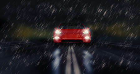 Red sports car drives fast through the rainy night, safety seasonal weather tire conceptの写真素材