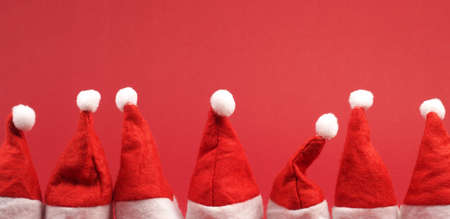 Hat of Santa in a row on a red background wth space for textの写真素材