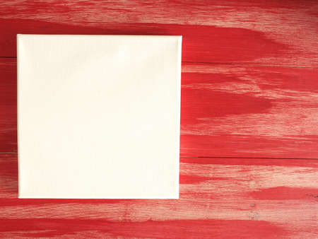 Invitation concept with a blank canvas on a red wooden background, invitation, greetings card, creativity at homeの写真素材
