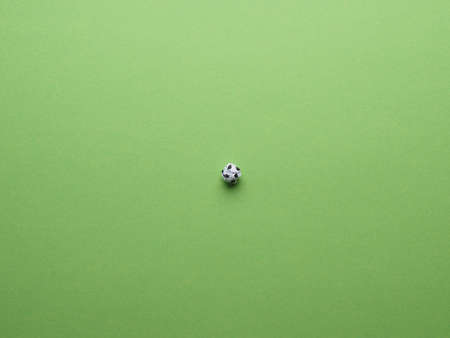Soccer field, view from above, crumpled paper ball as a soccer ball on a green paer background as lawnの写真素材