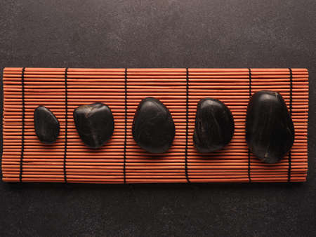 Five hot stones massage stones on a bamboo mat, health care, aromatherapy, header or backdropの写真素材