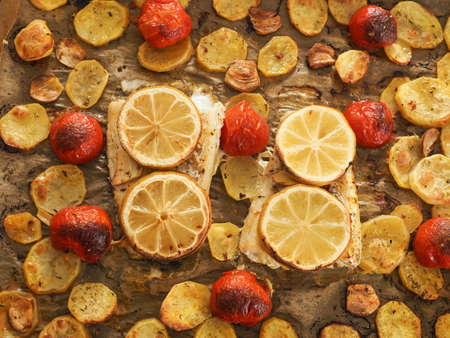 Cod fillet garnished with thyme, garlic and tomatoes, preparation of a healthy dish. Healthy food...