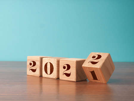 Flipping wooden cubes with the Year number 2021 and 2022, New Year concept, seasonal Christmas timeの写真素材