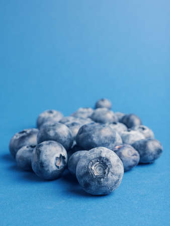A heap of blueberries on a blue backgrond with space for text, super food or healthy eating, fresh...