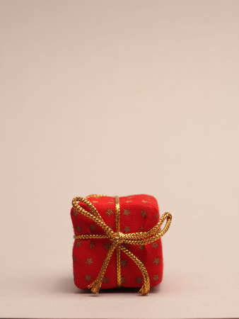 Red gift box on a bright background with space for your text or image, seasonal holiday concept