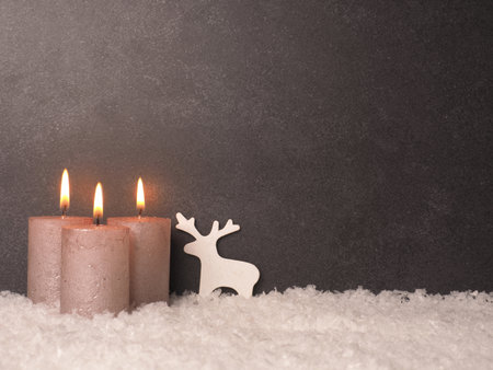 Third Advent candle burns, dark stone background with space for your text or imageの写真素材