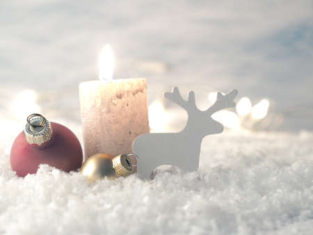 Christmas decoration in snow with candle, selective focus on Christmas tree balls in foreground, holiday backgroundの写真素材