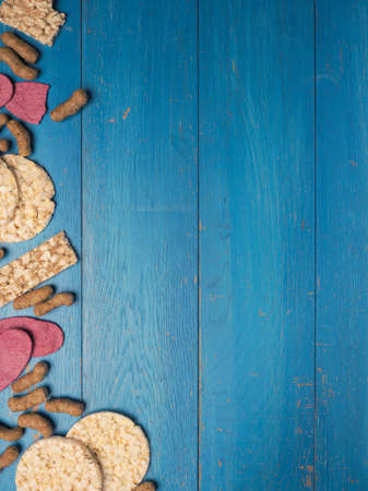 Organic crackers from lentils, beet, nuts and corn as a frame on a wooden background, space for your textの写真素材