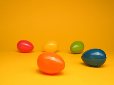 Colorful plastic Easter eggs on a yellow studio background, Happy Easter concept backdropの写真素材