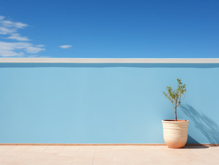 a plant in a pot sitting on a tiled floor in front of a blue wallの素材