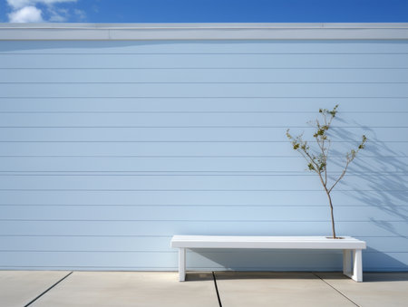 a white bench sitting in front of a blue wallの素材