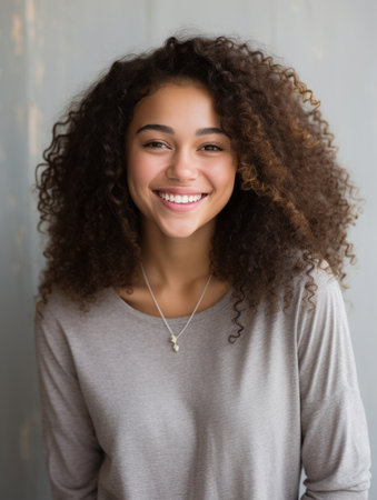 a young woman with curly hair smilingの素材
