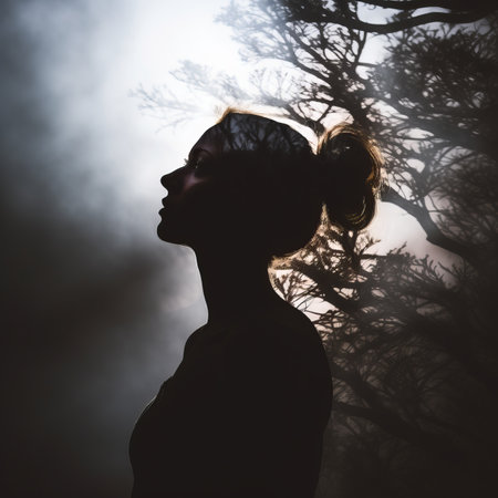 the silhouette of a woman standing in front of a treeの素材