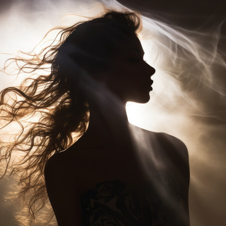 the silhouette of a woman with her hair blowing in the windの素材