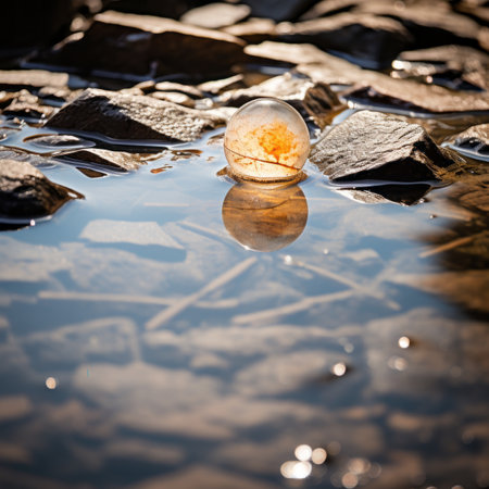 a glass ball floating in a puddle of waterの素材