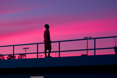 a person standing on a railing looking at the skyの素材