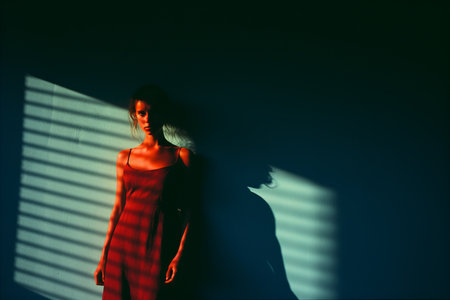 a woman in a red dress standing in front of a wallの素材