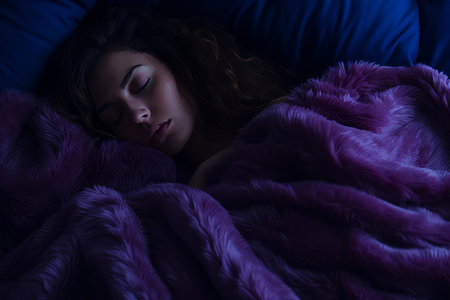 a woman sleeping under a purple blanketの素材