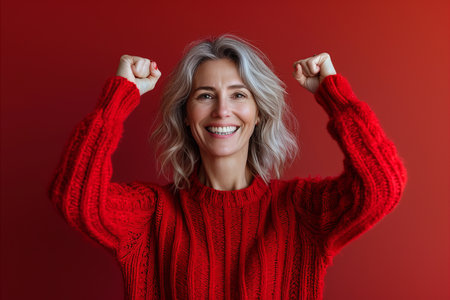 a woman in a red sweater raising her armsの素材