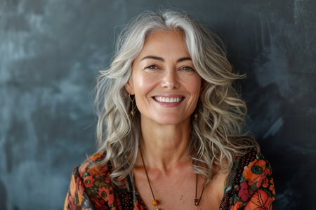 a woman with gray hair smiling in front of a blackboardの素材