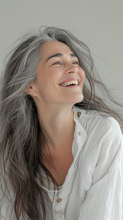 a woman with long gray hair is smilingの素材