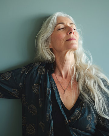 a woman with long white hair is leaning against a wallの素材