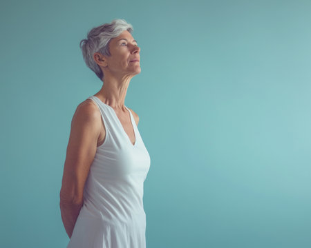 an older woman standing in front of a blue background