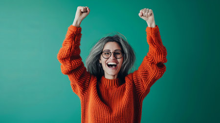 a woman in an orange sweater raising her armsの素材