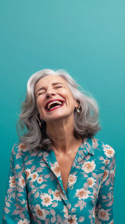 an older woman laughing while wearing a floral shirtの素材