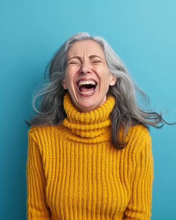 an older woman laughing and wearing a yellow sweaterの素材